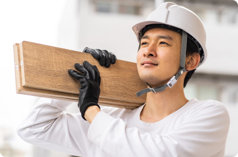 木材を運ぶ建設作業員の男性