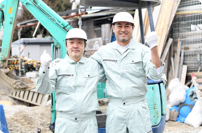 建設現場で笑顔の作業員2人